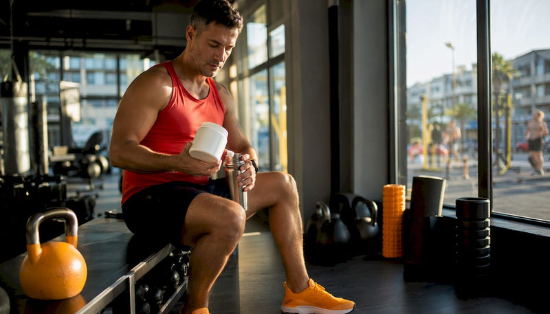 Athletic trainer preparing BCAA supplement drink in gym