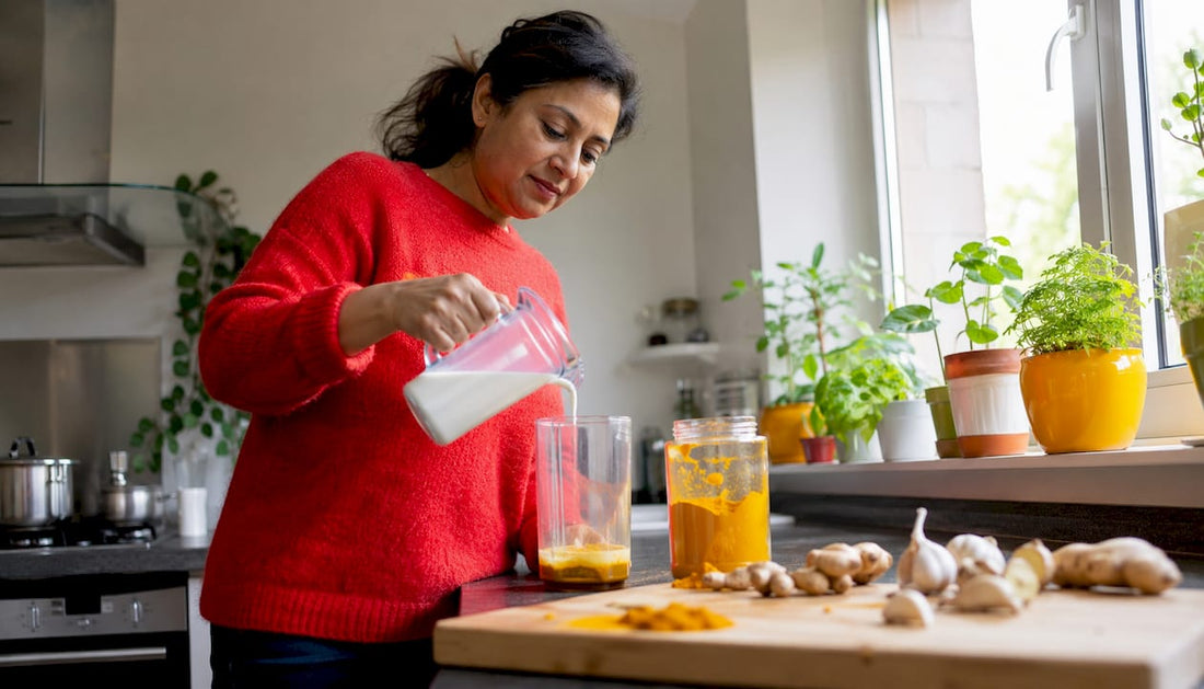 Woman preparing turmeric golden milk in kitchen