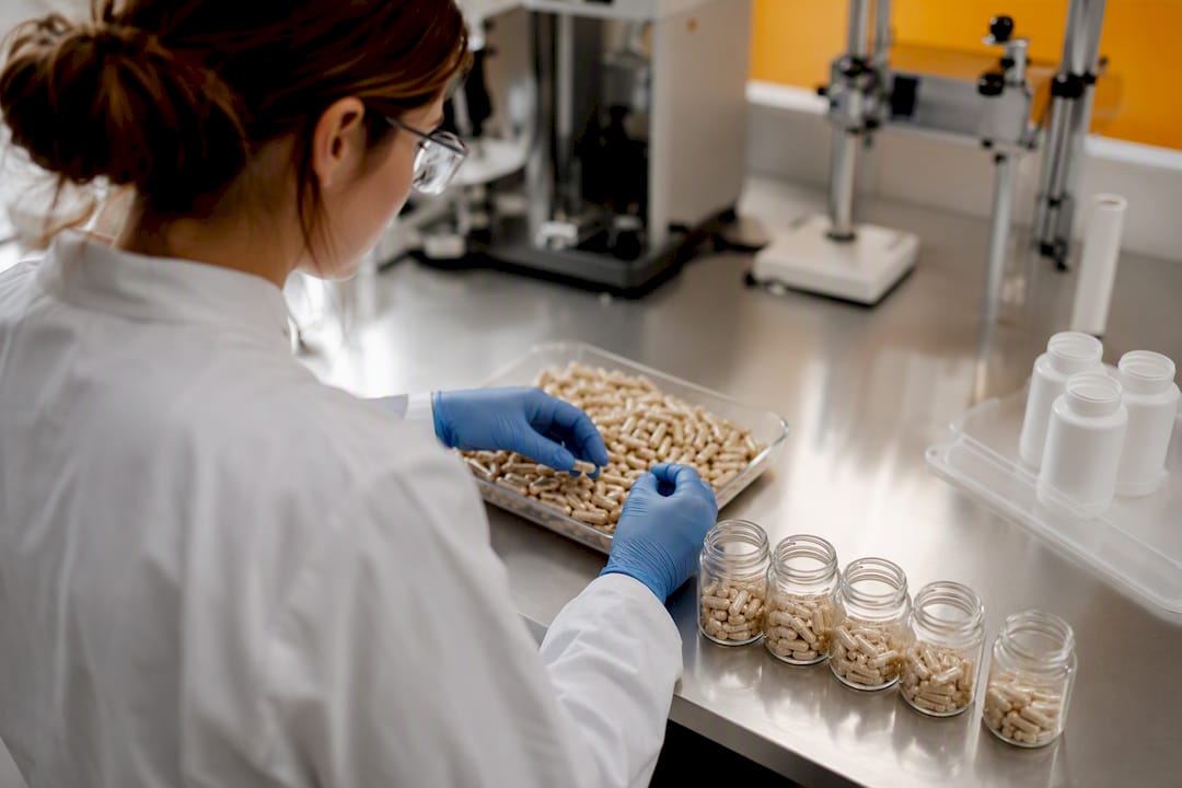 Lab technician handling supplement capsules